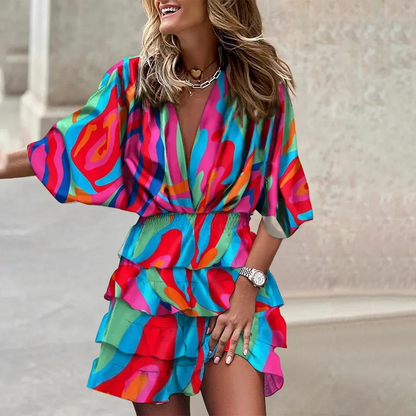 Pink - Black and beige tropical leaf print mini dress featuring a deep V-neckline, wide sleeves, smocked waist, and tiered ruffle skirt.