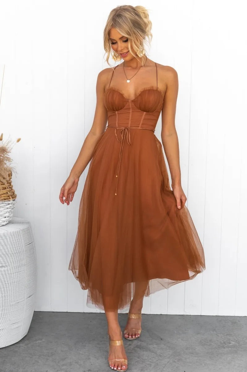 Brown - Rust brown tulle midi dress featuring a structured corset bodice with ruched cups, thin straps, a delicate waist tie, and a voluminous A-line skirt with a sheer hem.
