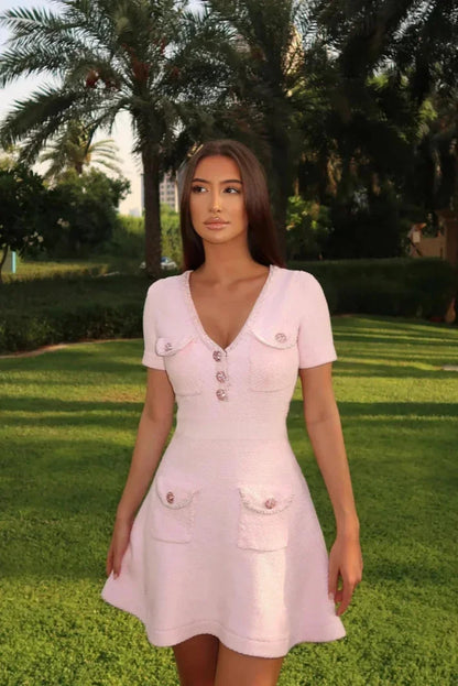 Pink - Light pink textured tweed short-sleeve mini dress featuring a V-neckline, button-front bodice, and four patch pockets with embellished buttons.